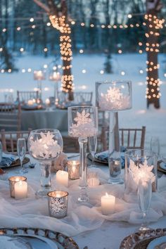 the table is set with candles and snowflakes on it for an elegant winter wedding