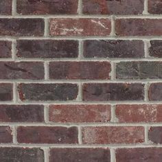 a brick wall that is made out of red and brown bricks with white mortars