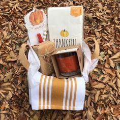 a basket filled with food sitting on top of a pile of leaves