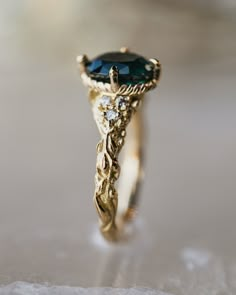 a close up view of a ring with a blue stone in the center and diamond accents