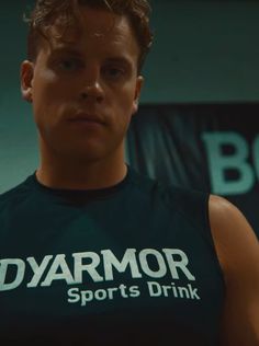 a young man wearing a green shirt with the words dymor sports drink on it