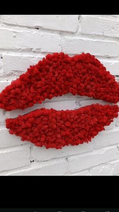 a red lipstick painted on a white brick wall