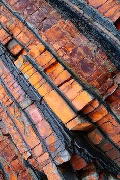 an old brick wall with orange and brown bricks