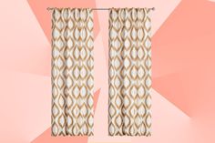 a pair of curtains with an orange and white pattern on them against a pink background