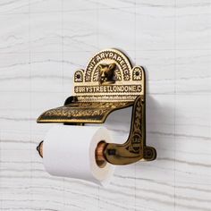 an old fashioned toilet paper dispenser on a marble wall with a roll of toilet paper hanging from it's holder