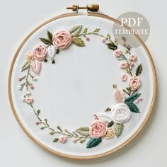 the embroidery hoop is decorated with pink and white flowers