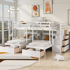 a bedroom with bunk beds and drawers in the floor, along with pictures on the wall