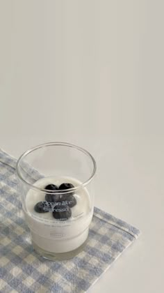 a glass bowl filled with black rocks sitting on top of a blue and white checkered cloth