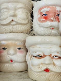 several ceramic santa claus heads are on display