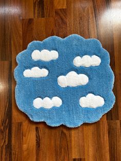 a blue rug with white clouds on it sitting on top of a hard wood floor