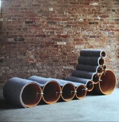 several pipes are lined up in front of a brick wall