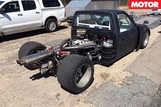 a car that is sitting on the ground in front of some other cars and trucks