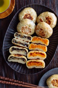 some food is sitting on a plate with chopsticks and a cup of tea