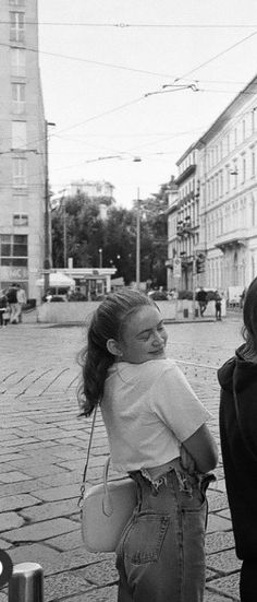 two women are walking down the street with one holding onto another woman's back