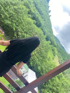 a person standing on a balcony with trees in the background