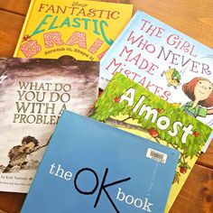 four children's books sitting on top of a wooden table