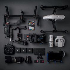 various cameras and accessories laid out on a black surface with one camera attached to the other