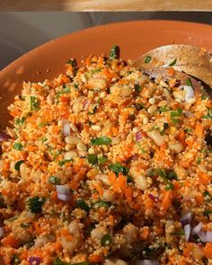 a bowl filled with rice and vegetables on top of a table