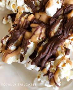 chocolate covered popcorn with caramel drizzled on top and marshmallows in the middle