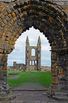 an archway leading to a large building with a clock tower in the middle of it