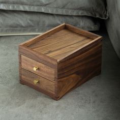 a wooden box sitting on the floor next to a couch