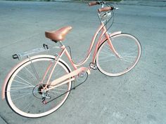 an old pink bicycle is parked on the street