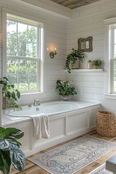 a white bathroom with two windows and a bathtub next to a rug on the floor