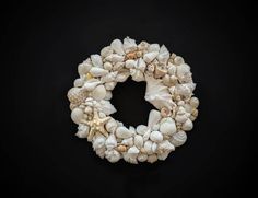 a wreath made out of seashells on a black background