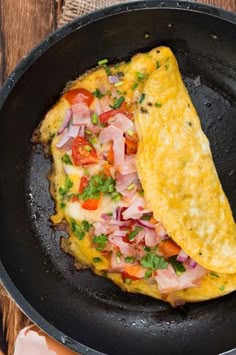 an omelet with meat and vegetables in a skillet