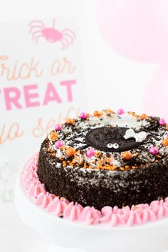 a chocolate cake with sprinkles and pink icing on a white plate