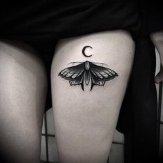 a woman's thigh with a moth tattoo on her lower leg and the moon behind it