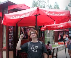 a man standing under an umbrella in front of a store