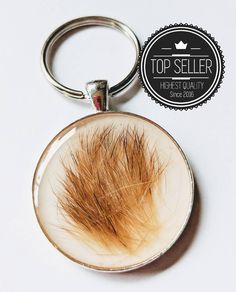 a close up of a keychain with a hair on the inside of it