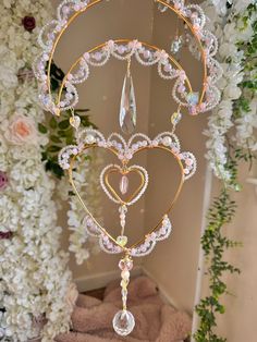 a heart - shaped decoration hanging from the ceiling next to flowers