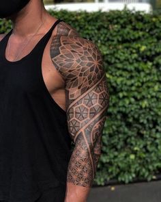 a man with a black mask on his face and arm is wearing a sleeve tattoo