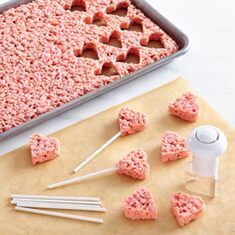 the ingredients for making heart shaped rice krispy kreme treats are displayed on a baking sheet