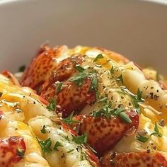 a white bowl filled with pasta and meat covered in cheese, sauce and parsley