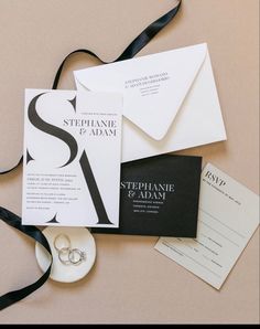 the wedding stationery is laid out on top of each other, including two rings