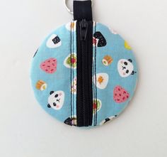 a blue coin purse with pandas and other animals on it, hanging from a hook