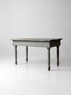 an old wooden table sitting on top of a white floor