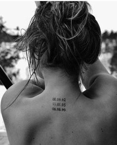 the back of a woman's neck with numbers tattooed on her upper and lower back