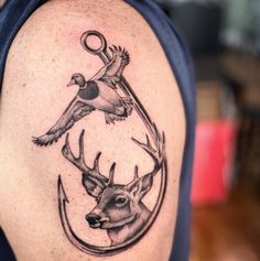 a tattoo on the arm of a man with a deer and bird in it's head