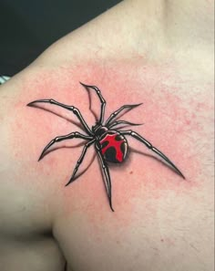 a spider tattoo on the back of a man's upper arm and chest, with a red heart in it