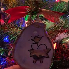 a christmas ornament with an image of a person on it hanging from a tree