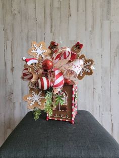 a bouquet of christmas decorations on top of a cushion in front of a wooden wall