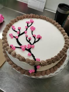 a cake decorated with pink flowers on top of a table