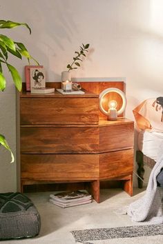 a bedroom scene with focus on the dresser and bed side table in the foreground