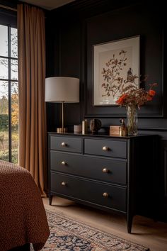 a bedroom scene with focus on the dresser and bed side table in the foreground