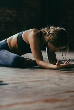 a woman is doing yoga on the floor