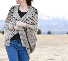 a woman wearing a crocheted shawl in the desert